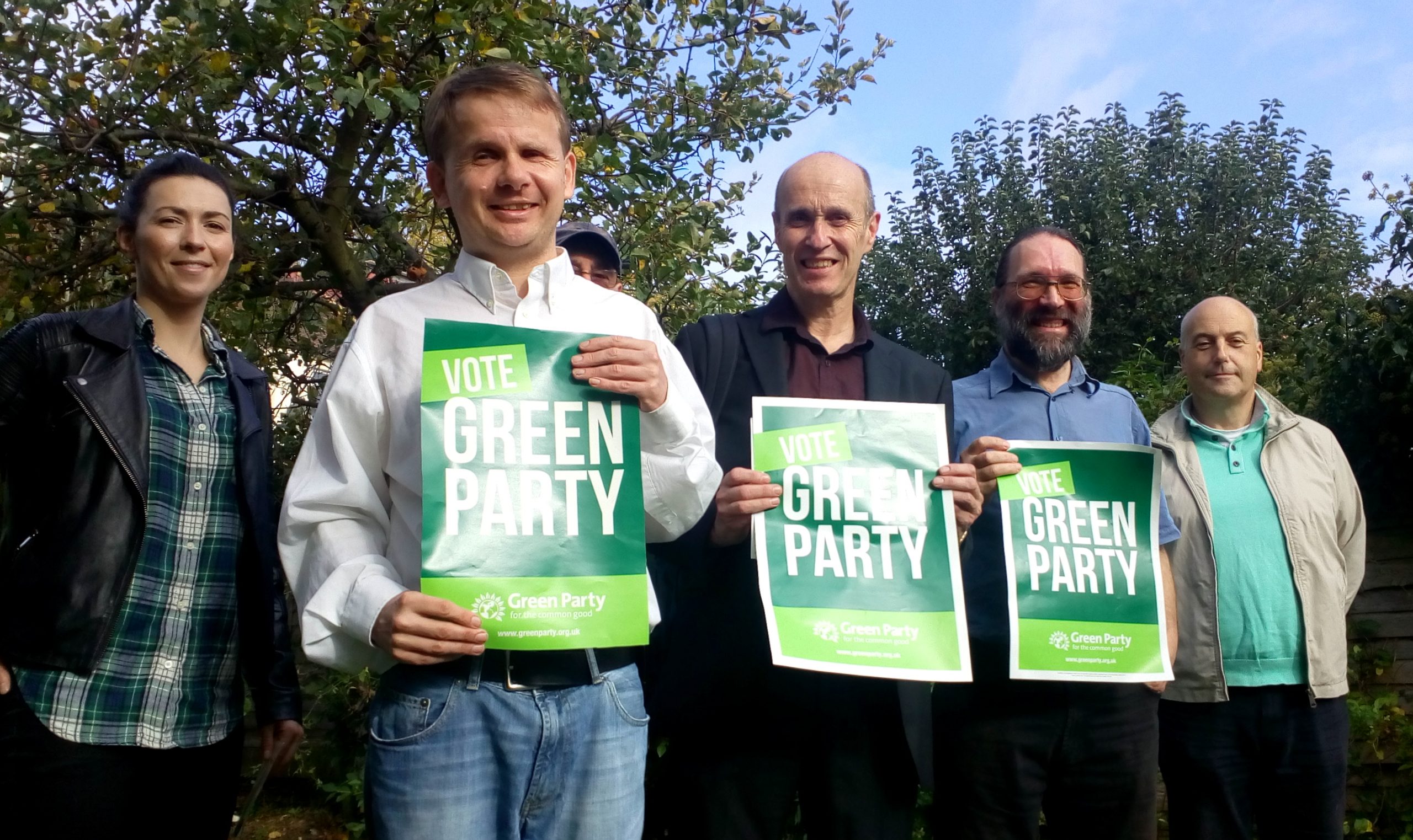 Smiling Epping Forest Green Party membes on a sunny day in front of trees